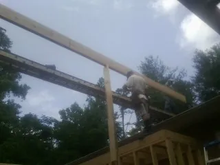 Carpenter setting a ridge beam over a new addition frame — Ice Dam Removal by Roofing Brothers in Rockaway Beach