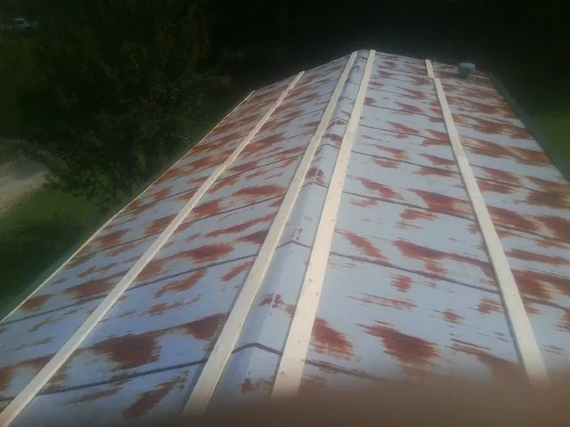 Rusted metal roof panels with new wood purlins before replacement — Storm Damage Roof Repair in Rockaway Beach by Roofing Brothers