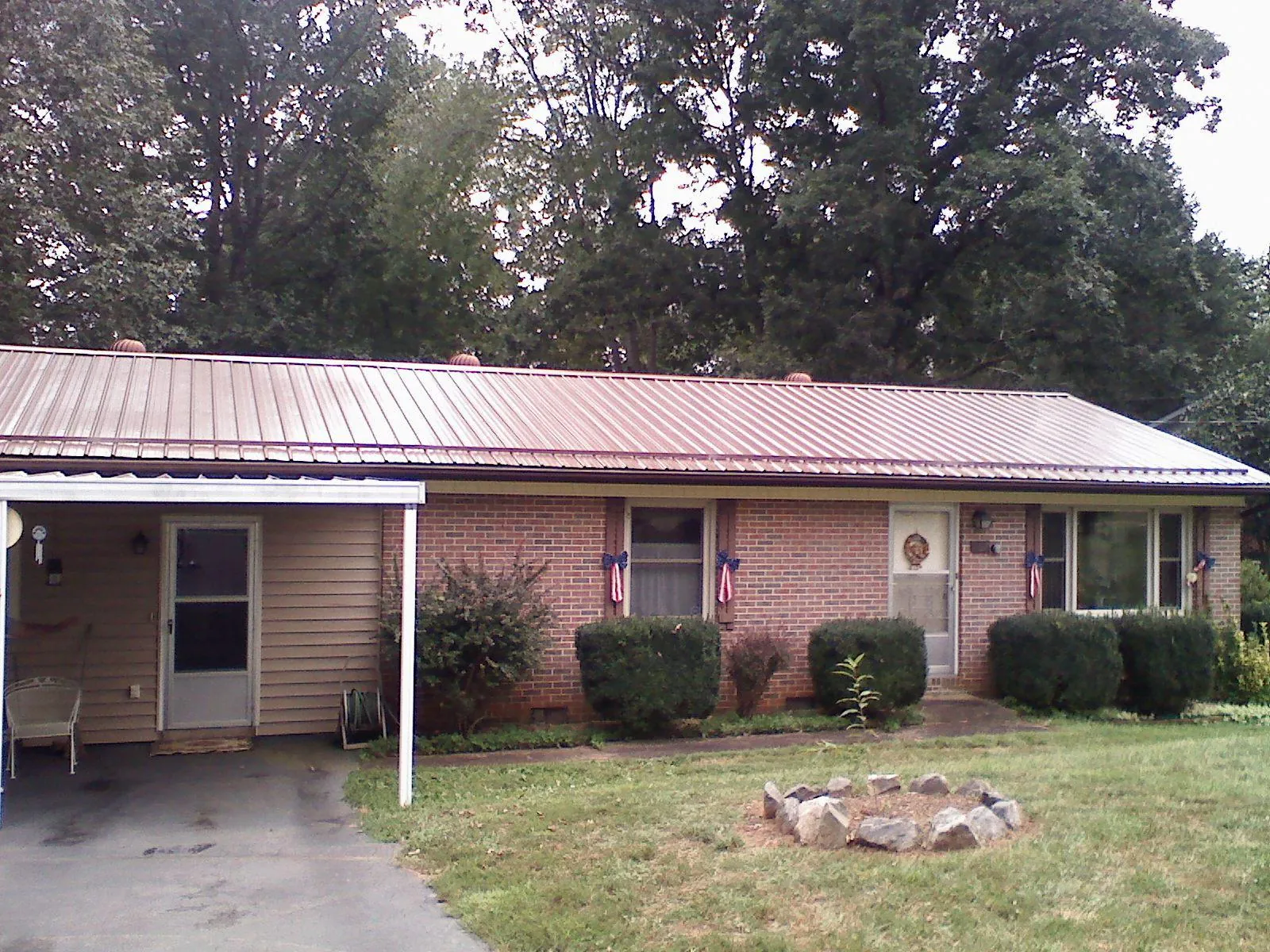 Bronze metal roof and carport on a brick ranch home — Roof Repair work by our crew in Rockaway Beach